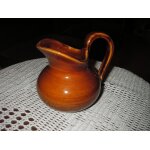 Pichet a lait en porcelaine de marque st clment france n 5028 , de couleur marron .