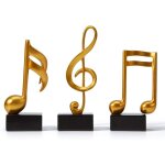 Ensemble de 3 statues dcoratives en rsine reprsentant des notes de musique.