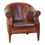 Un fauteuil club robuste mais confortable en cuir de mouton et fini avec des clous dcoratifs