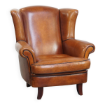 Fauteuil à oreilles en peau de mouton avec passepoil noir Fauteuil à oreilles en peau de mouton avec passepoil noir