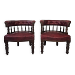 Paire de fauteuils tonneau en bois tourné et cuir bordeaux productio Paire de fauteuils tonneau en bois tourné et cuir bordeaux productio