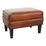 Pouf en cuir de mouton avec finition passepoile noire