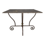 Table en fer forg� � pi�tement sculptural, orn�e de volutes