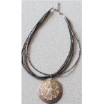 Collier form� de 5 fils de perles rondes / allong�es sur lesquels coulisse un m�daillon avec forme incrust�e ...