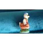 Fève brillante = une jolie oie habillée en femme, petit chapeau bleu et robe - socle vert - hauteur 39 ... Fève brillante = une jolie oie habillée en femme, petit chapeau bleu et robe - socle vert - hauteur 39 ...