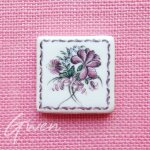 Feve clamecy carreaux de mosaïque fleur miniature signé en creux dans la pate Feve clamecy carreaux de mosaïque fleur miniature signé en creux dans la pate