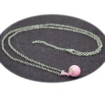 Collier bola de grossesse rose avec empreintes de petits pieds