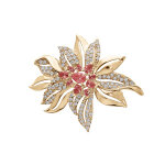 Broche en plaqué or motif fleur avec oxydes fuschia et blancs sertis Broche en plaqué or motif fleur avec oxydes fuschia et blancs sertis